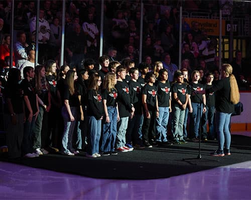 A school anthem group singing on the ice at a Hershey Bears game.