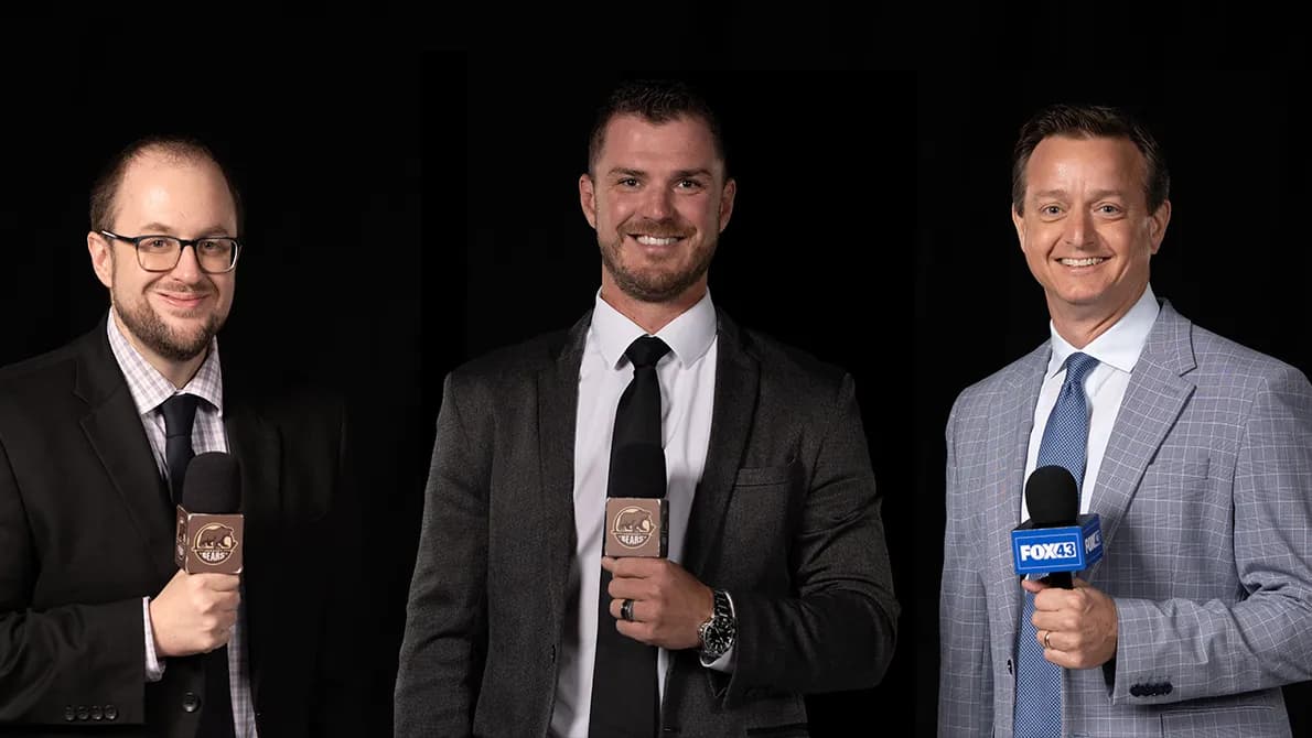 The Hershey Bears broadcast team standing with microphones.